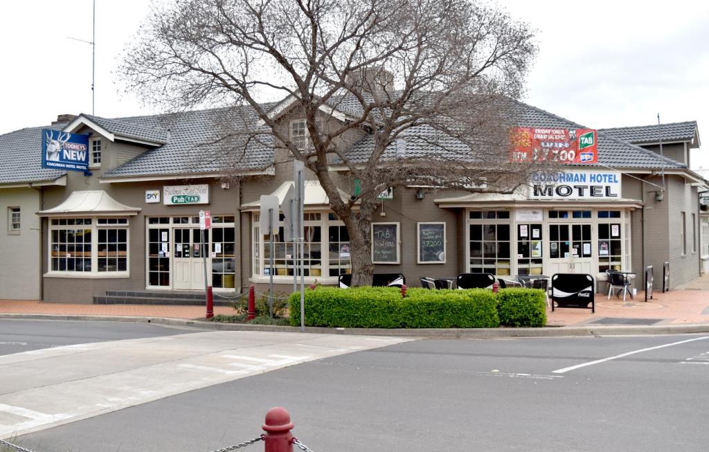 a motel building on the corner of a street at Coachman Hotel Motel in Parkes