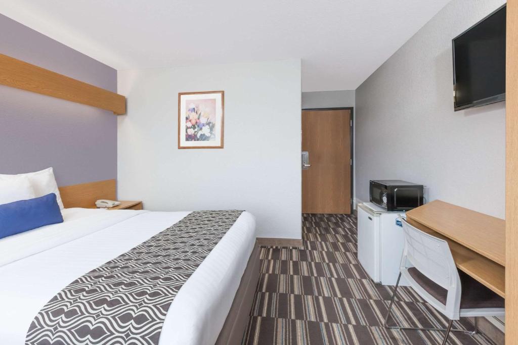 a hotel room with a bed and a desk at Microtel Inn & Suites by Wyndham Ardmore in Ardmore