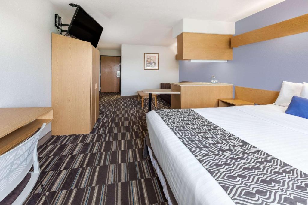 a hotel room with a large bed and a kitchen at Microtel Inn & Suites by Wyndham Ardmore in Ardmore