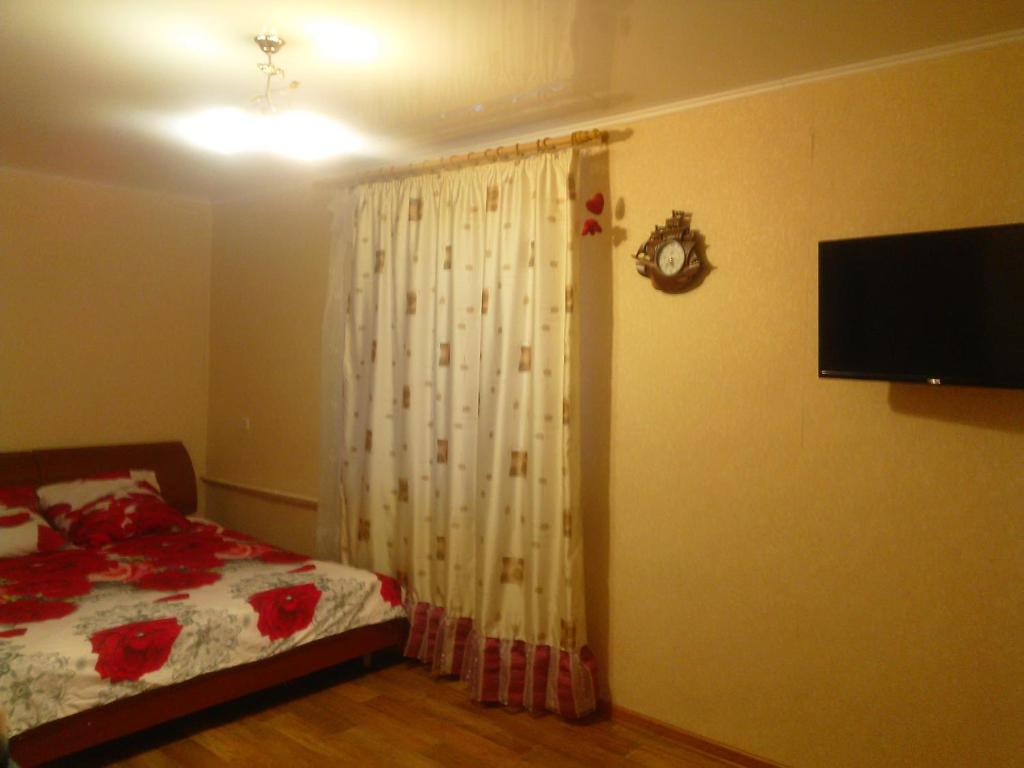 トムスクにあるКвартира в ЦЕНТРЕ на проспекте Ленинаのベッドルーム1室(ベッド1台、壁掛けテレビ付)