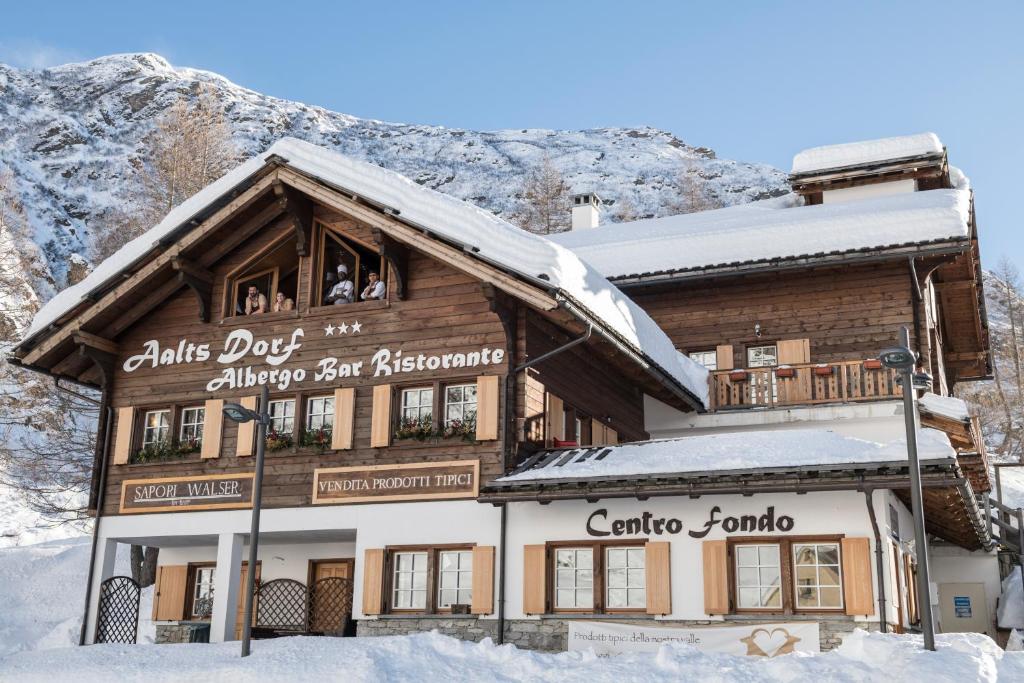 un edificio en la nieve con una montaña en el fondo en Aalts Dorf en Riale