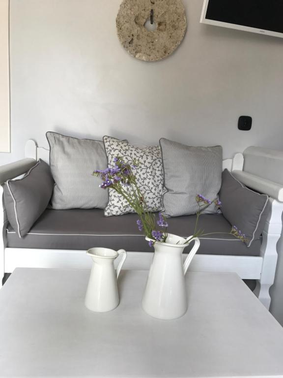 a living room with a couch and two vases on a table at Spitaki Serifos Studio in Rámos