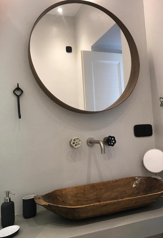 a bathroom with a wooden sink and a mirror at Spitaki Serifos Studio in Rámos