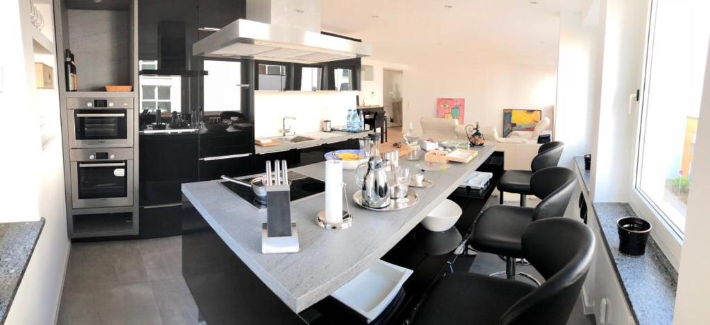 a kitchen with a large table with black chairs at Apartment Central Würzburg in Würzburg