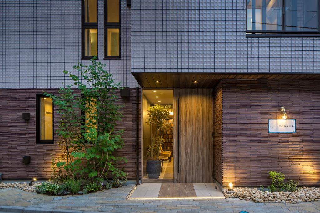 une maison en briques avec une porte d'entrée en verre dans l'établissement Hotel SAILS, à Tokyo