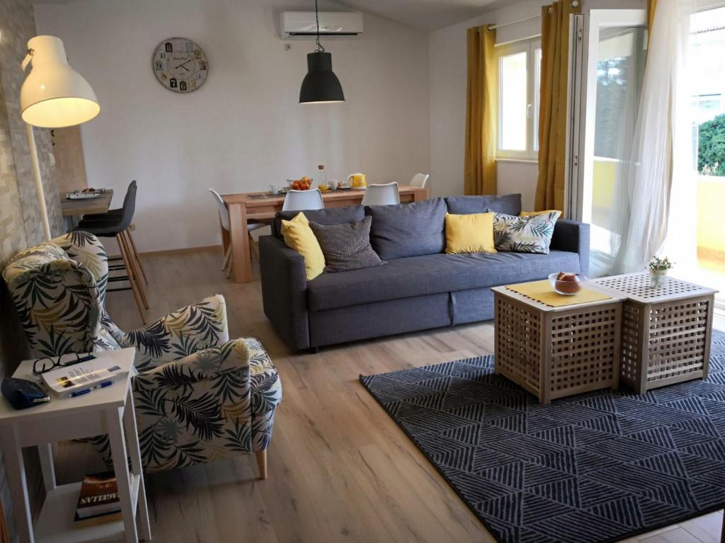 a living room with a blue couch and a table at Sea and pine paradise in Orebić