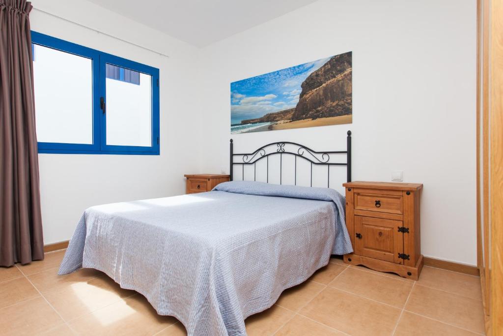 a bedroom with a bed and a large window at TAO El Cotillo in El Cotillo