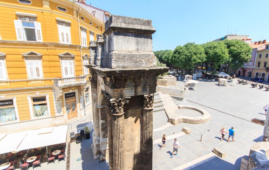 a view of a building with a statue in a street at Appartment in center with parking in Pula