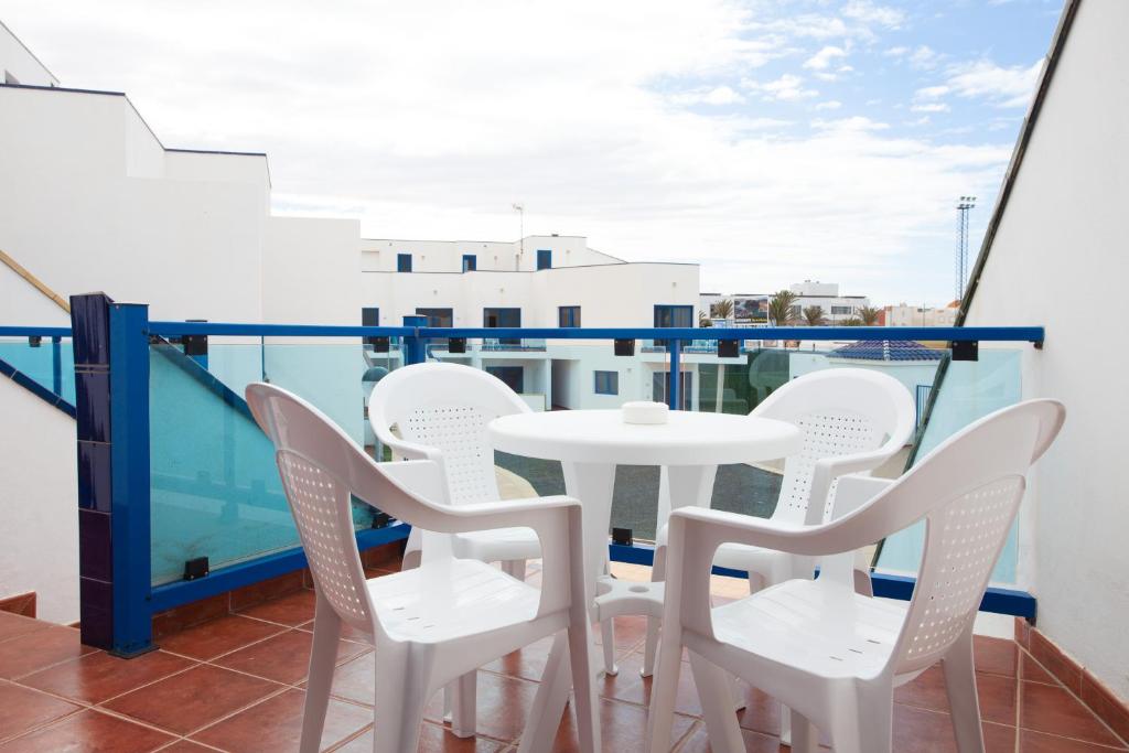 a balcony with a white table and chairs at TAO El Cotillo in El Cotillo