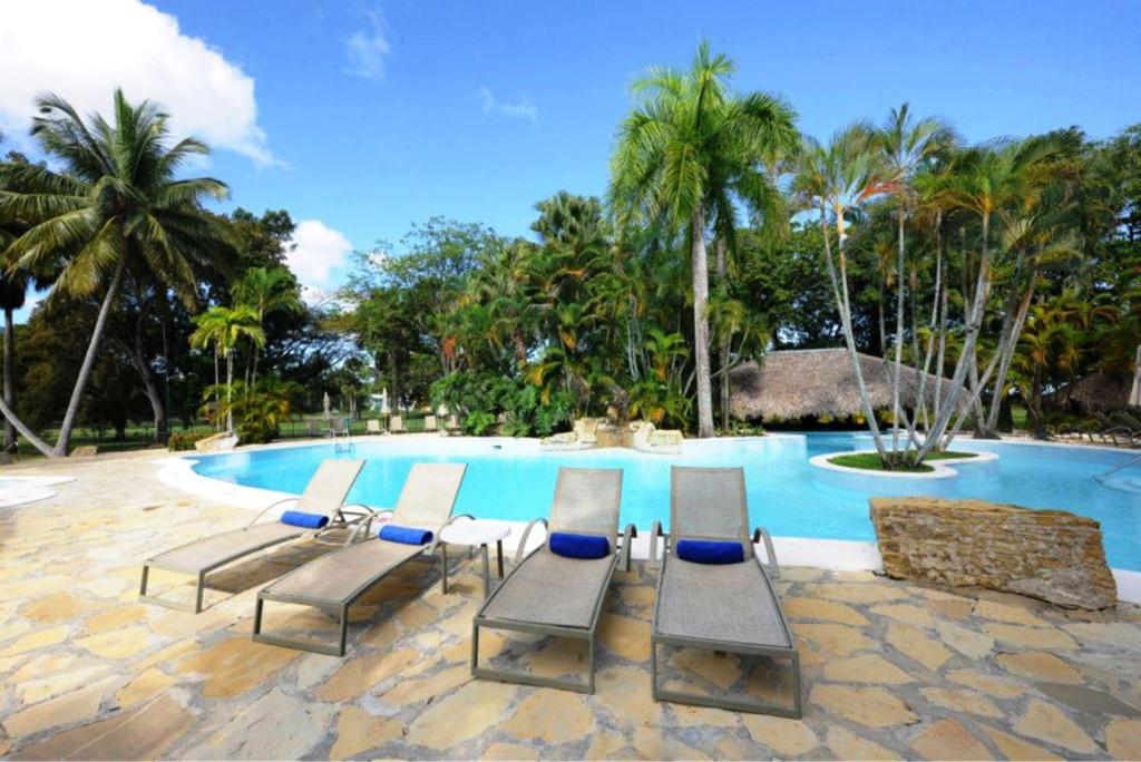 eine Gruppe von Stühlen neben einem Pool in der Unterkunft Blue JackTar in San Felipe de Puerto Plata