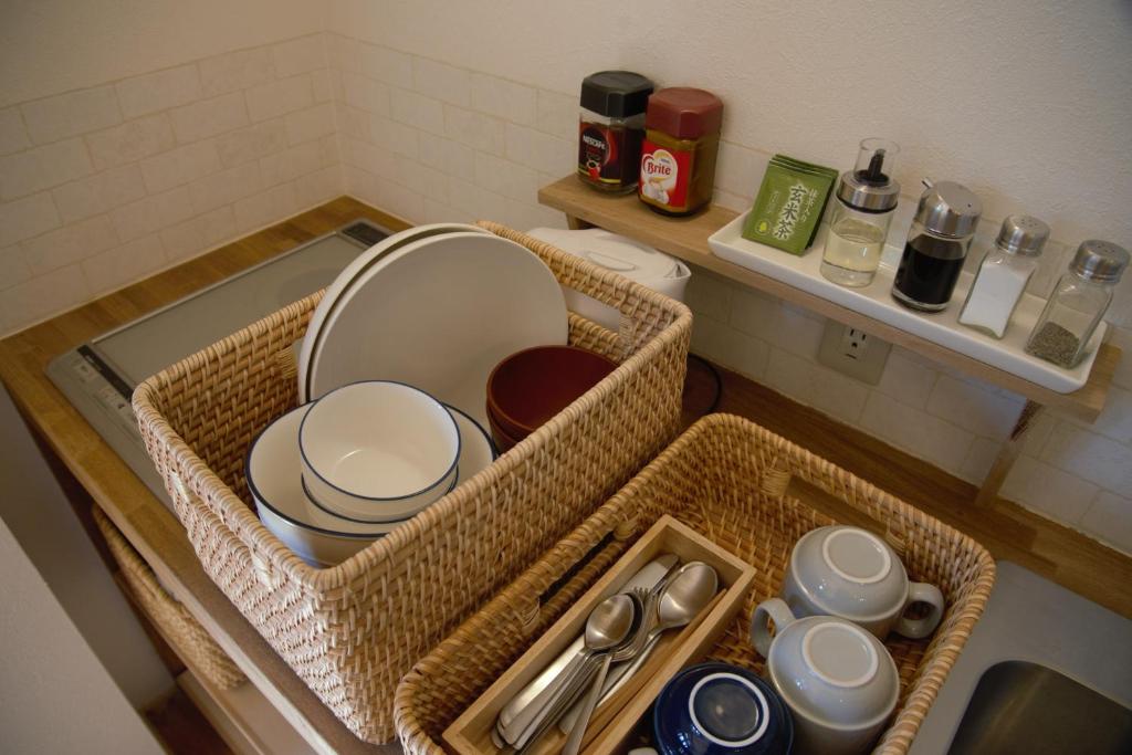 a bathroom counter with baskets and dishes on a sink at Mountain Home Lodge in Deer Park in Nara