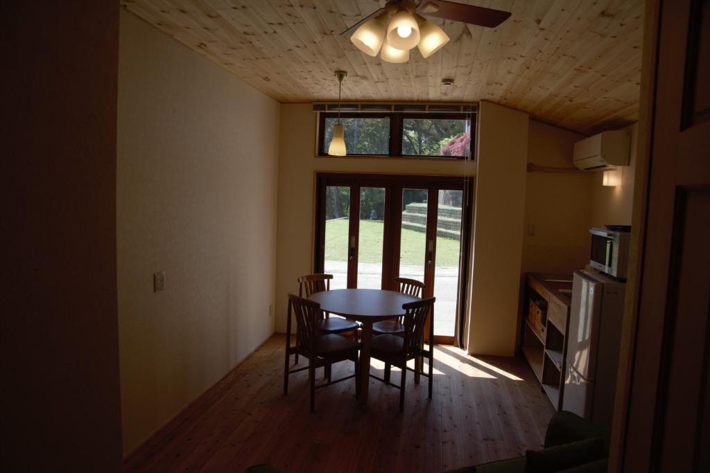 a dining room with a table and chairs and a window at Mountain Home Lodge in Deer Park in Nara
