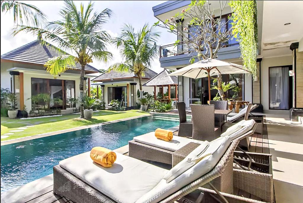 a villa with a swimming pool and a house at Lebak Bali Residence in Canggu