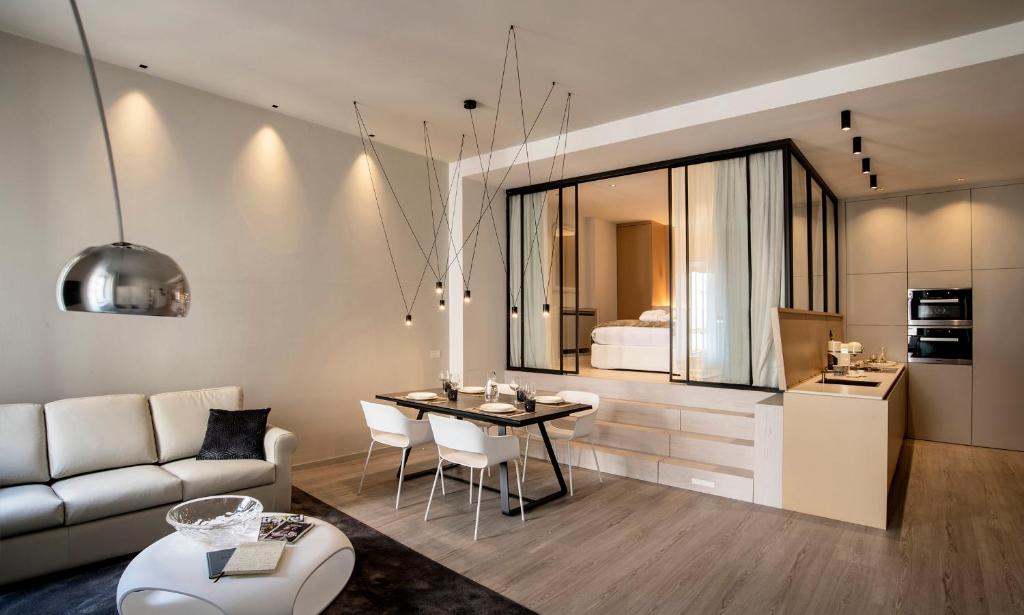 uma sala de estar com um sofá, uma mesa e uma cozinha em Cinquanta4 Charme Apartment em Trento
