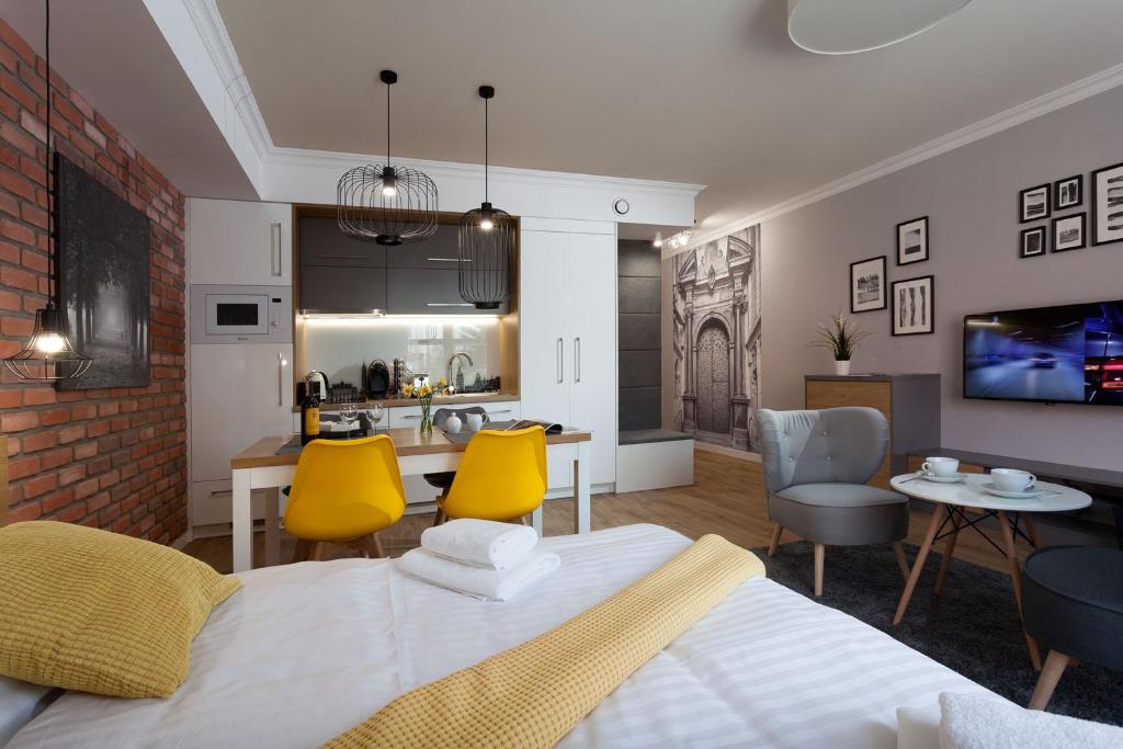 uma sala de estar com uma cama e uma sala de jantar em Silver Apartment Old Jewish Quarter em Cracóvia