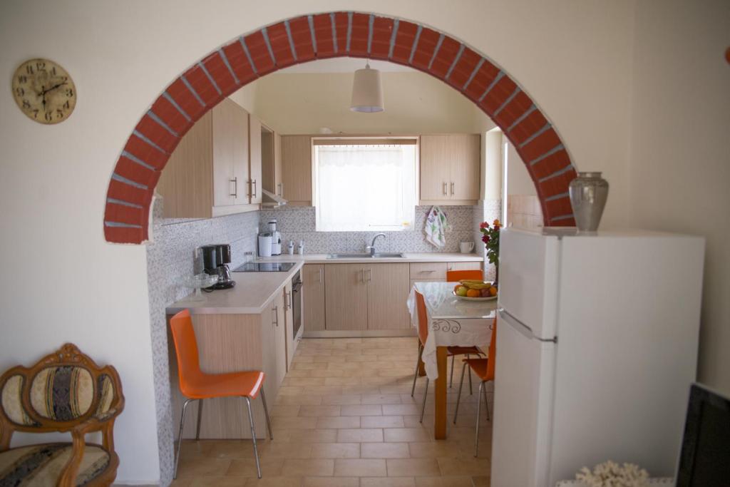 an archway in a kitchen with a table and a refrigerator at Irini Kalyves II in Kalyves