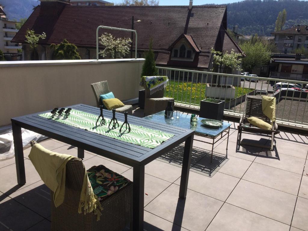 - une table et des chaises sur une terrasse avec un toit dans l'établissement La Terrasse Saint Jean, à Annecy