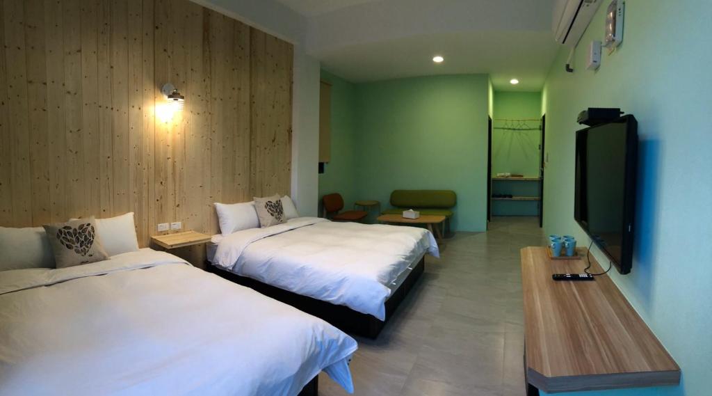 a hotel room with two beds and a flat screen tv at Kenting Peninsula Inn in Kenting