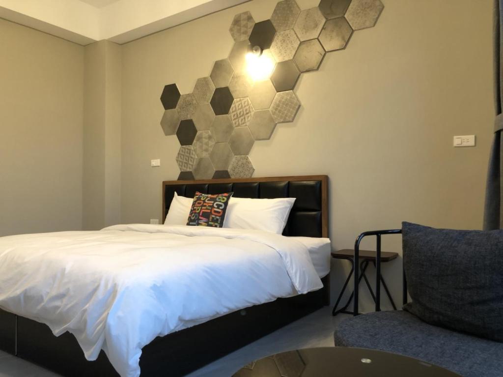 a bedroom with a bed and a chair at Kenting Peninsula Inn in Kenting