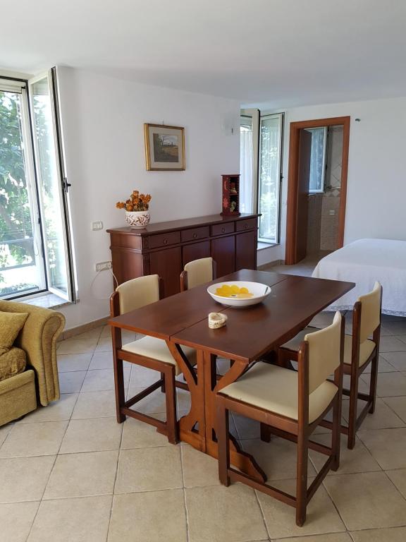 a dining room with a wooden table and chairs at Lodge Rosa in Agropoli