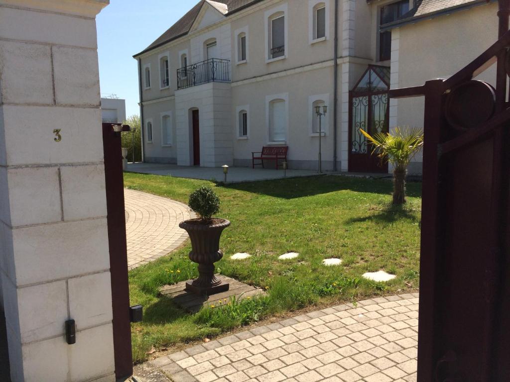 una puerta abierta a una casa con una planta en el patio en CoTTAGE LA VILLA BOLERO en Saint-Cyr-sur-Loire