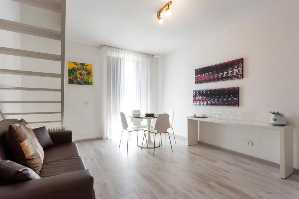 sala de estar con sofá y mesa con botellas de vino en Alcalà Living Apartments, en Catania