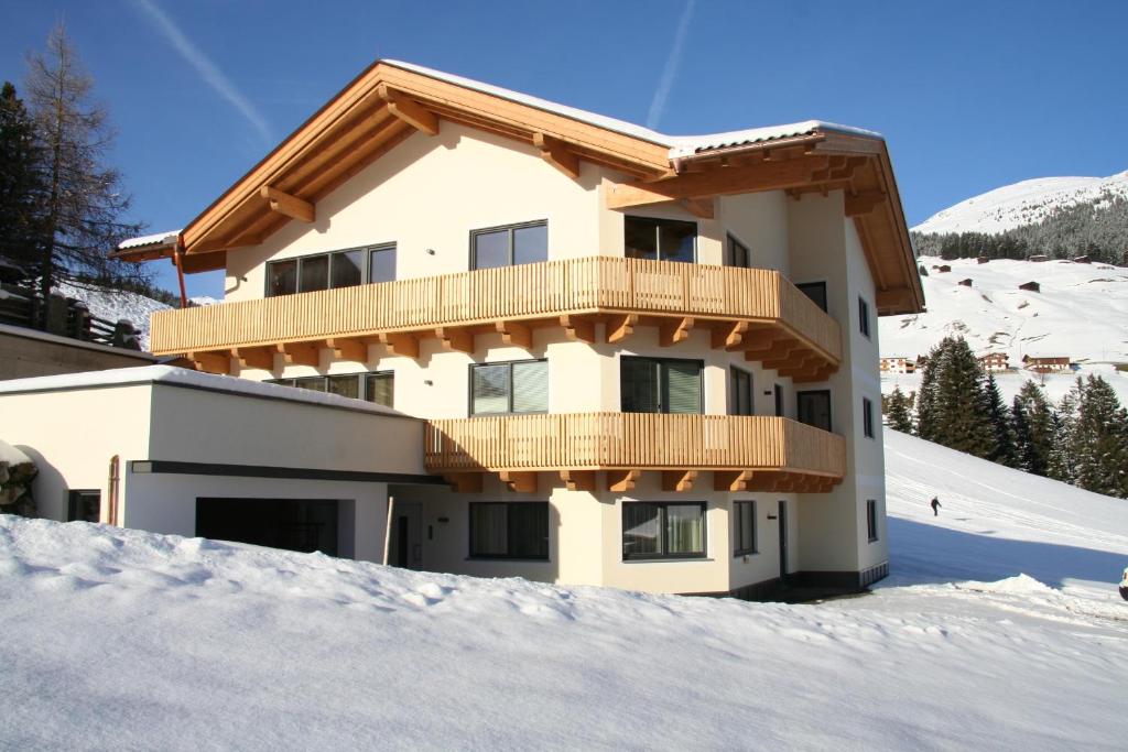 トゥクスにあるFerienwohnung am Winterhausの雪の中のバルコニー付きの家