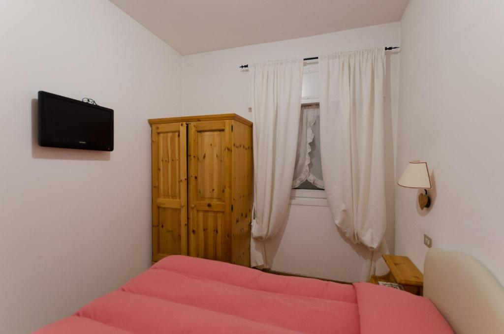 um quarto com uma cama vermelha e uma janela em Appartamento Continental - 8 posti letto em San Vito di Cadore