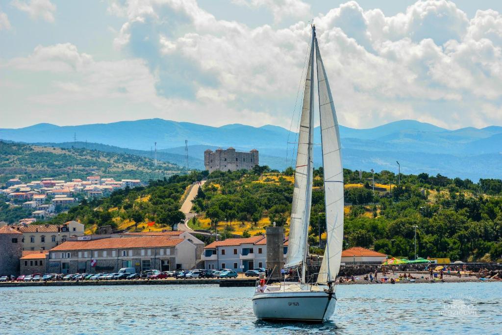 um veleiro na água em frente a uma cidade em Apartment Marina em Senj