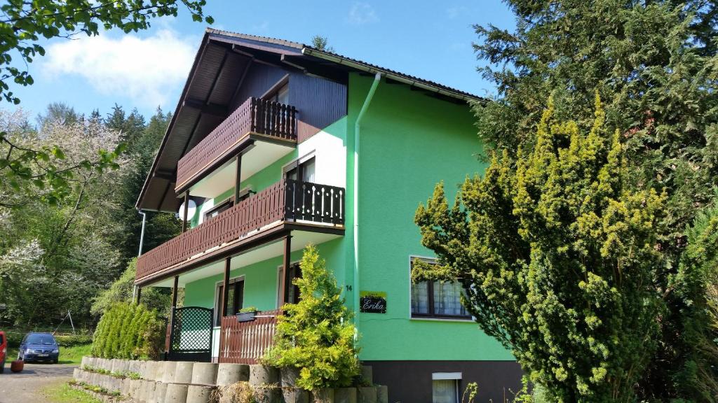 ein grünes und weißes Haus mit Balkonen und Bäumen in der Unterkunft Ferienhaus Erika in Zorge