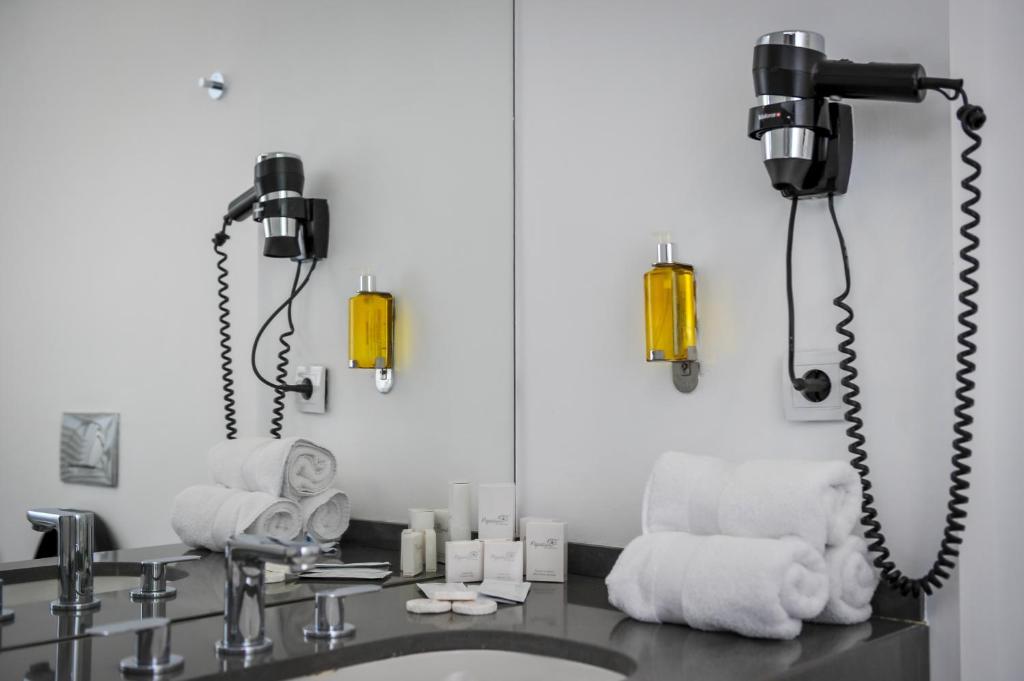 a bathroom area with a sink, mirror, and towel dispenser at Apart Hotel Vlad Tepes in Braşov