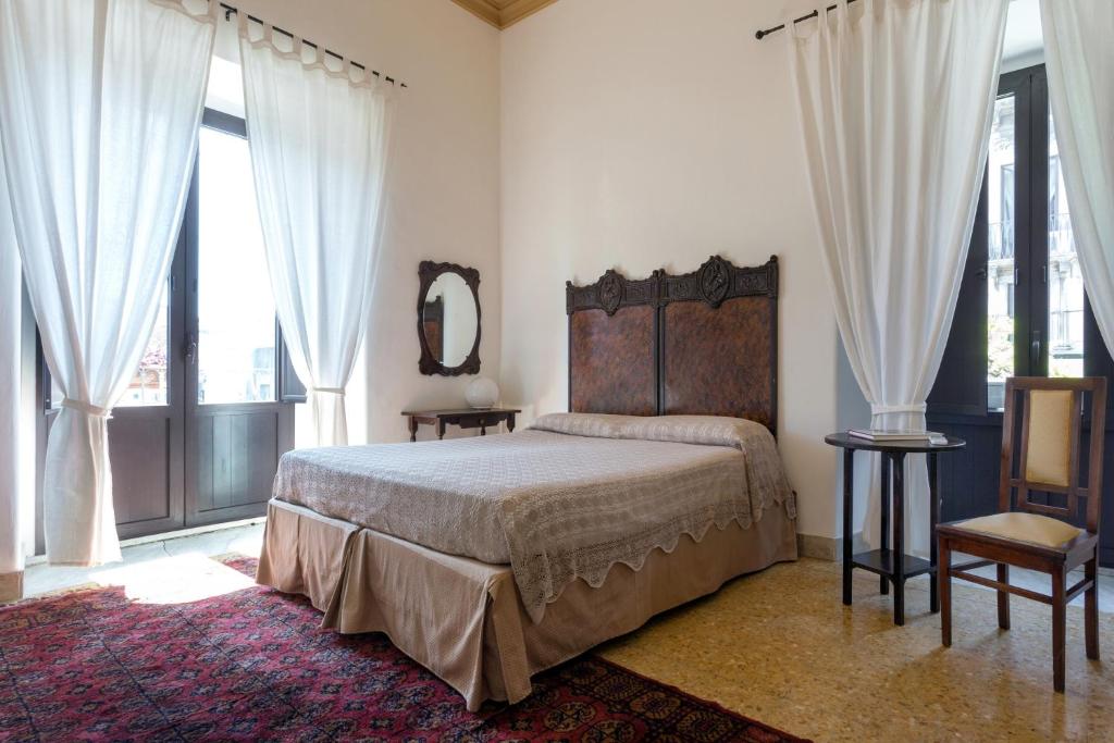カターニアにあるAlcalà Living B&Bのベッドルーム1室(ベッド1台、鏡、窓付)