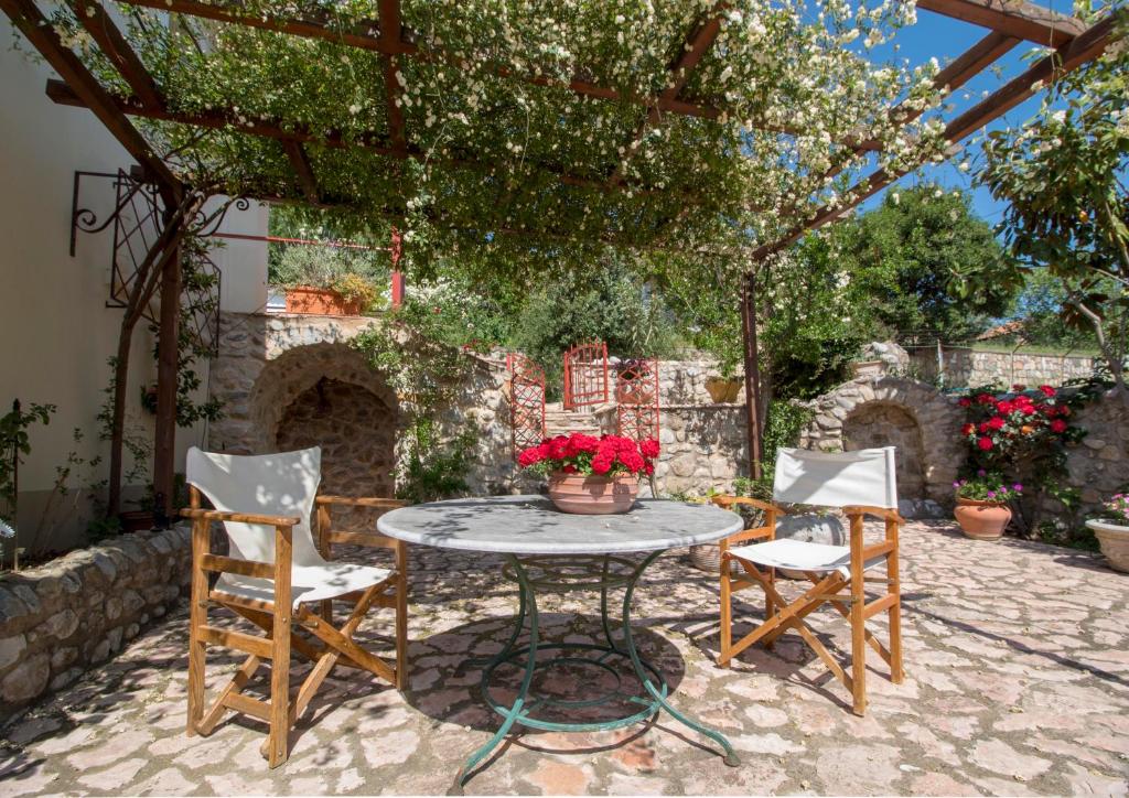 een patio met een tafel en stoelen onder een pergola bij Laconian Collection Ano Chora Vordonia in Sparta