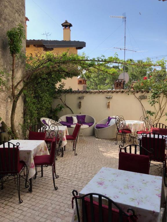 un patio extérieur avec des tables et des chaises dans l'établissement Locanda Agli Angeli, à Gardone Riviera