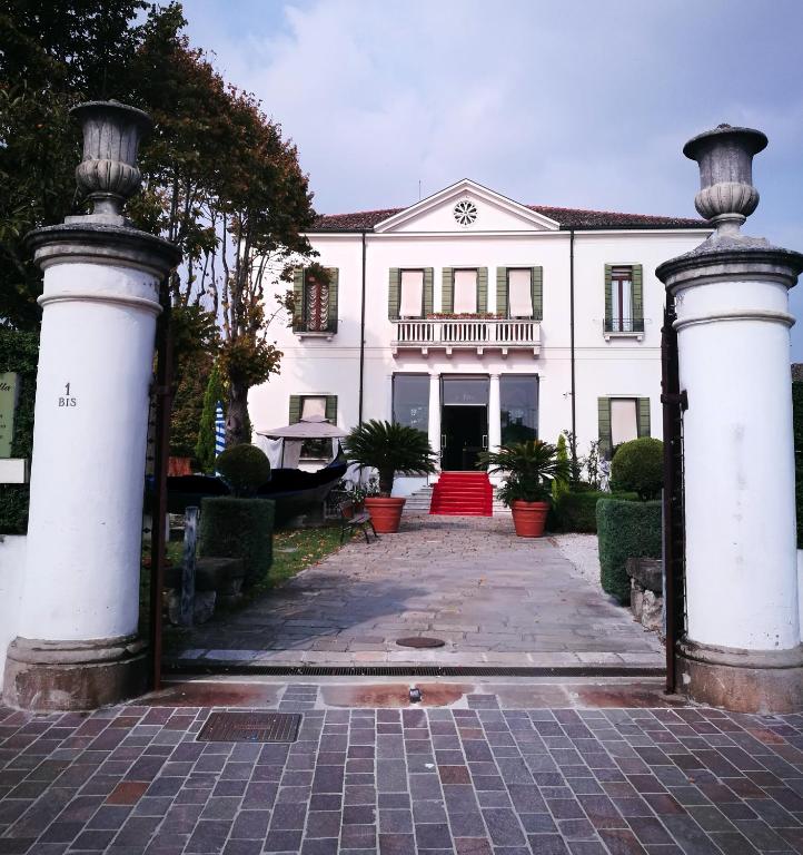 Biały dom z bramą przed nim w obiekcie Hotel AB Baretta w mieście Legnaro