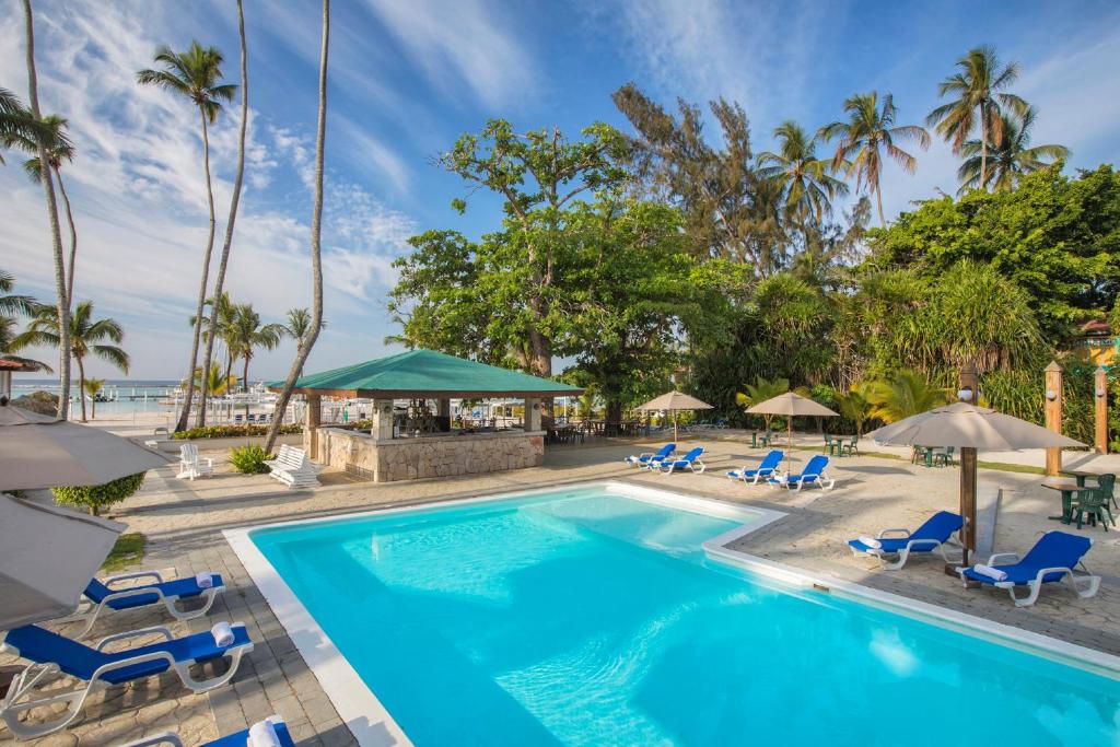 a pool with chairs and umbrellas at a resort at Hotel whala!boca chica - All Inclusive in Boca Chica