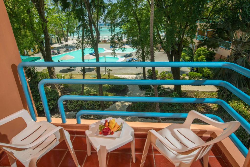a balcony with chairs and a view of a pool at Hotel whala!boca chica - All Inclusive in Boca Chica