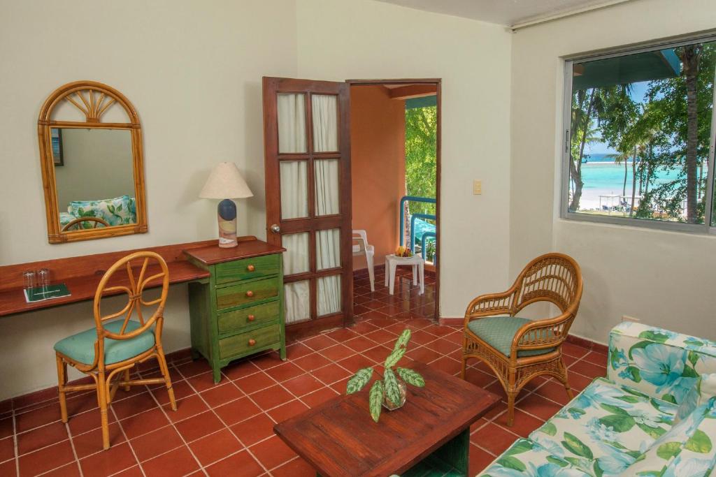 a living room with a desk and chairs at Hotel whala!boca chica - All Inclusive in Boca Chica