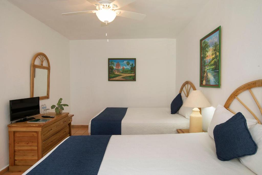 a hotel room with two beds and a television at Hotel whala!boca chica - All Inclusive in Boca Chica