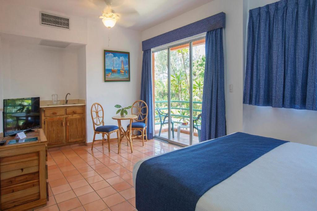 a bedroom with a bed and a television and a balcony at Hotel whala!boca chica - All Inclusive in Boca Chica