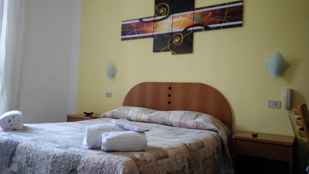 米蘭的住宿－Hotel Tirreno，卧室配有两张床,墙上有一个十字架