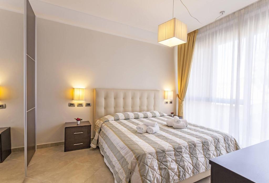 1 dormitorio con 1 cama grande y toallas. en ApartHotel Anghel, en Siena