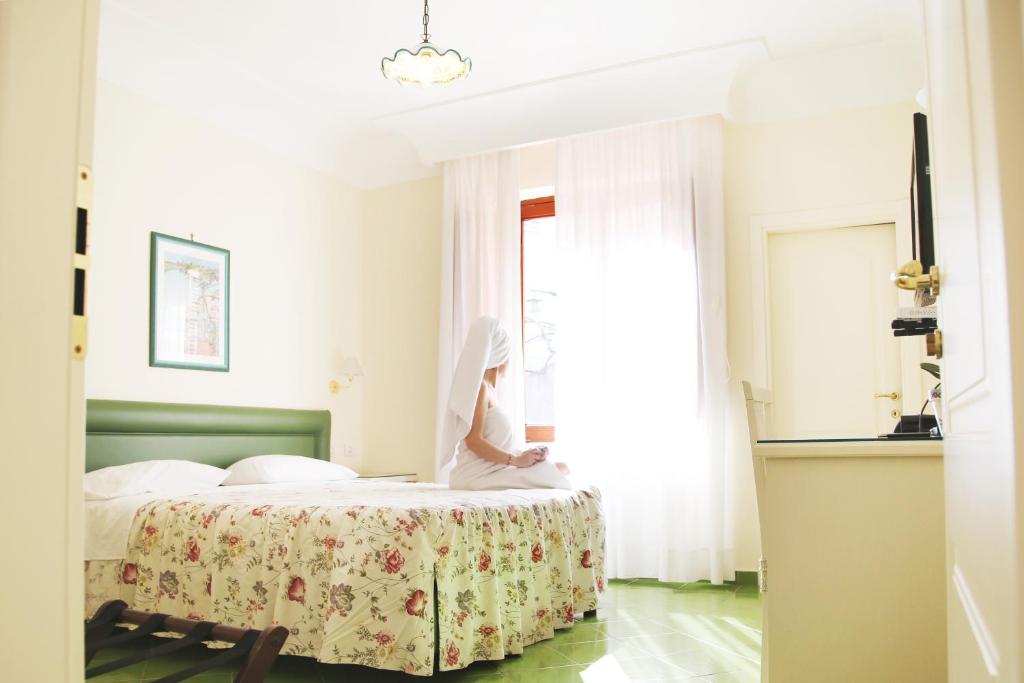 a bedroom with a bed with a table and a window at A Casa Dei Nonni in Ravello