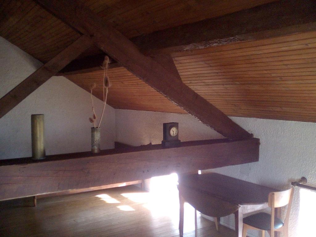 a wooden table in a room with a wooden ceiling at Le Gîte de Réaumur in Réaumur