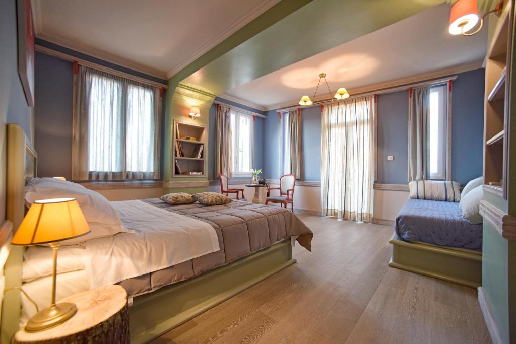 een slaapkamer met een bed en een tafel en stoelen bij Puppet Guesthouse in Corfu-stad