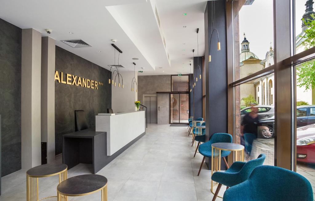 a lobby of a restaurant with blue chairs at Hotel Alexander in Krakow