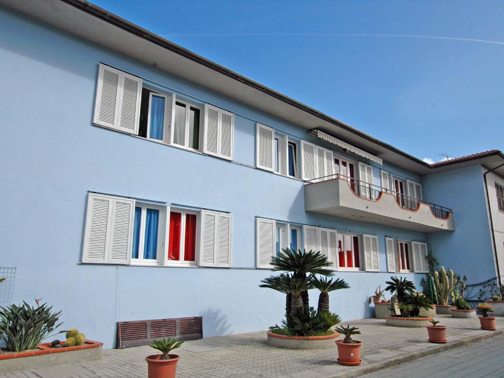un edificio azul con ventanas blancas y macetas en Residence Il Pavone en Marina di Campo