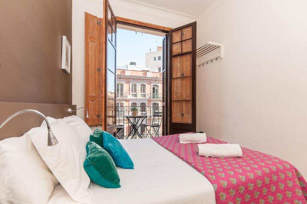 a bedroom with a bed and a large window at Weflating Sant Antoni Market in Barcelona