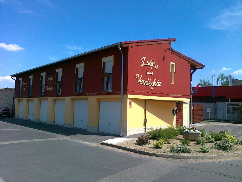 un bâtiment rouge et jaune avec un panneau sur lequel figure un panneau dans l'établissement Zsófia Panzió Pápa, à Pápa