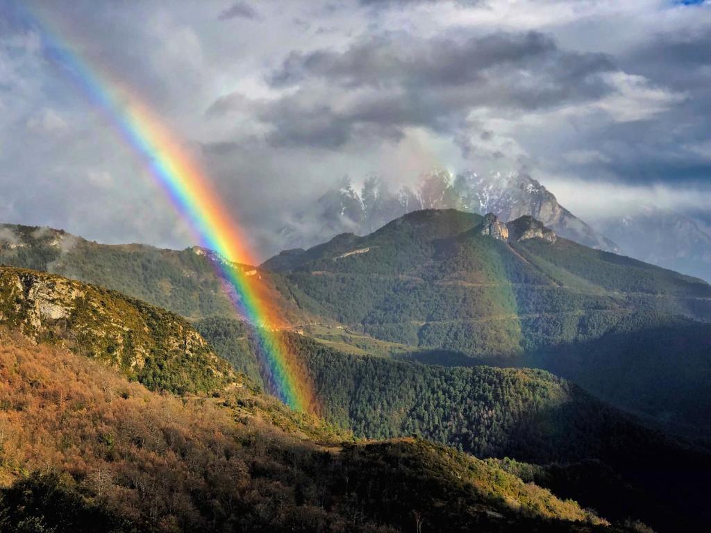 un arco iris frente a una montaña en La Posada de Silvan, en Tella
